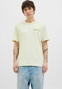 Lichtgroene katoenen t-shirt met een losvallende pasvorm, korte mouwen en een bedrukt logo met de tekst "ORIGINALS" in bruin-geel.