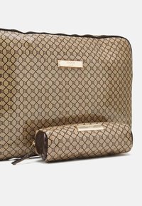 Ensemble de trousses cosmétiques à motif doré et marron avec un design hexagonal, des accents brillants et une quincaillerie dorée portant l'étiquette de la marque. Fermeture à glissière.