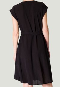 Robe noire à manches courtes, taille ceinturée et jupe fluide. Dotée d'un tissu texturé et d'un design simple et classique.