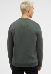 Gray sweatshirt with a textured finish, crew neck, ribbed cuffs, and hem, featuring a triangular back seam detail.