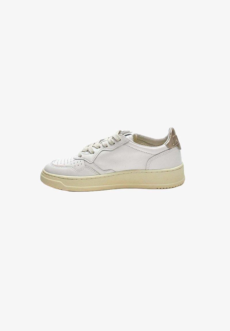 Sneaker in pelle bianca con design perforato, suola in gomma beige e dettaglio metallico oro sul tallone. Chiusura con lacci e superficie liscia.