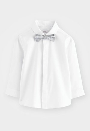 Biała koszula z długim rękawem z podwiniętym kołnierzem i srebrnym, teksturowanym muszkiem na środku przy szyi na jednolitym tle.
