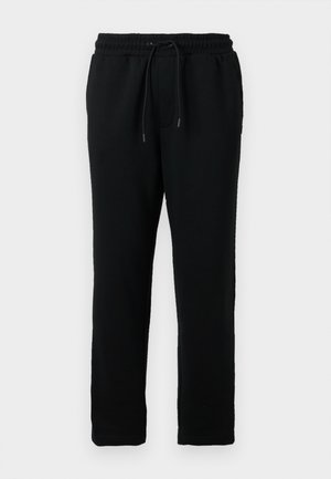 Svarte bomullssweatpants med elastisk midje, snøring for justering og smalere ben. Jevn tekstur og ingen synlige mønstre.
