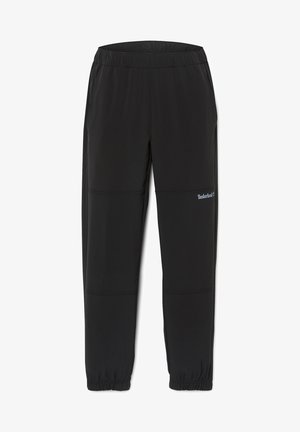 Pantalon de sport noir en matériau léger, doté d'une taille élastique, d'une coupe fuselée et du logo Timberland sur le côté.