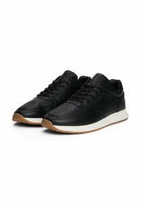 Sneaker in pelle nera con finitura liscia, dotate di lace frontali, una suola intermedia bianca e una suola esterna in gomma color caramello.