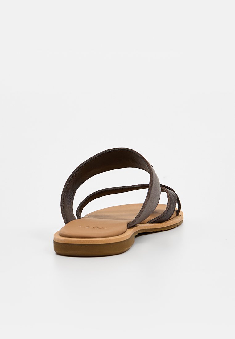 Sandalia de cuero marrón con tres tiras delgadas, suela plana y una plantilla ligeramente texturizada para mayor comodidad. Diseño minimalista en un tono neutro.