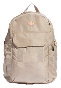Beige soft fabric backpack with a front pocket, two straps, a top handle, and a small embossed logo. Features a smooth texture and zipper closure.