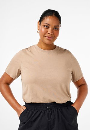 Beige cotton t-shirt with short sleeves, round neckline, and a relaxed fit, paired with black elastic waistband pants. Smooth texture.