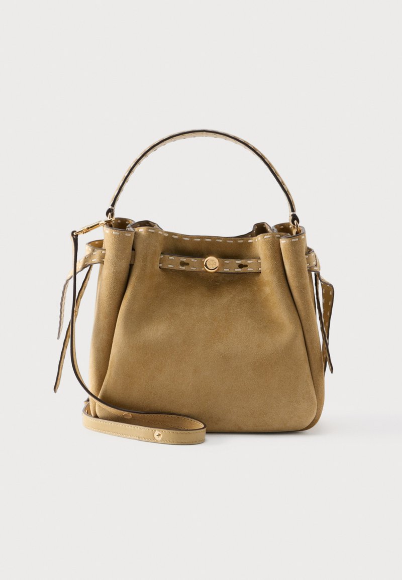 Καφέ τσάντα από σουέτ με ραμμένο δερμάτινο περιθώριο, λαβή στο πάνω μέρος, διακοσμητικό κουμπί μπροστά και αποσπώμενο ιμάντα ώμου σε μονόχρωμο φόντο.