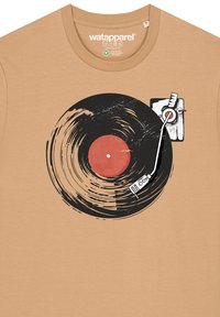 Beige T-shirt met een afbeelding van een zwarte vinylplaat en een stylus. De plaat heeft een rode midden en krassen voor detail.