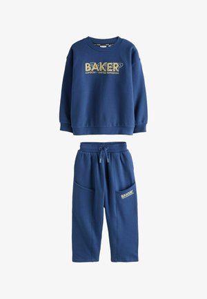 Navyblå sweatshirt og matchende bukser med "Baker London United Kingdom" logo i gult på brystet og bukselommen.