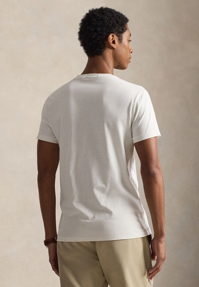 Tricou alb cu mâneci scurte și decolteu rotund, realizat din bumbac moale, cu o textură fină și un design simplu.