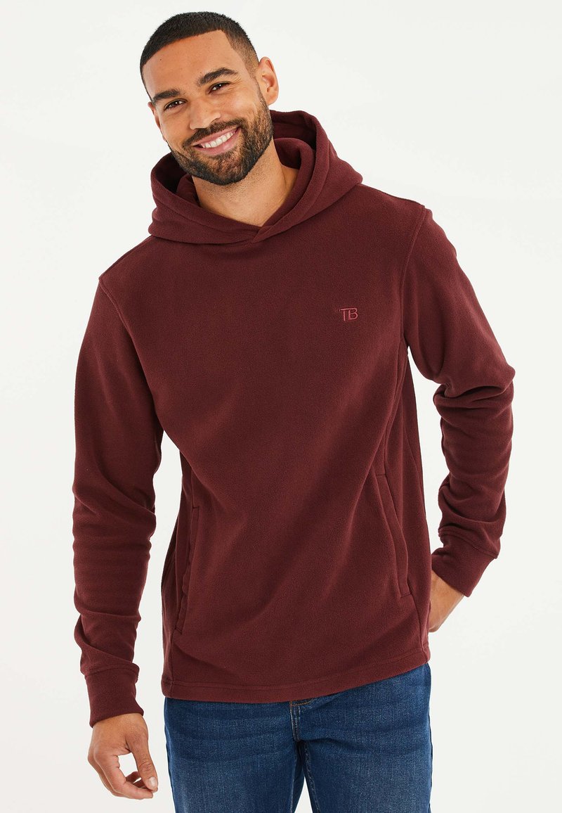 Bordeauxroter Fleece-Hoodie mit einer Fronttasche, weichem Material, verstellbarem Kordelzug in der Kapuze und dezentem Logodetail auf der Brust.