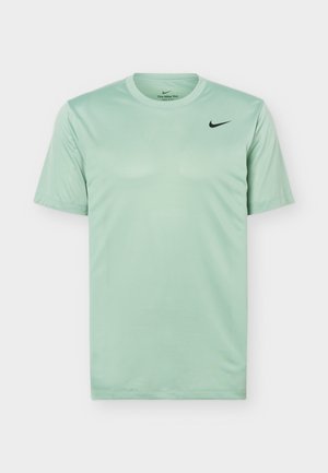 Hele rohelise lühikeste varrukatega Nike Dri-FIT jõudlusalune t-särk ümara kaelusega ja väikese musta Nike logoga vasakul rinnal.