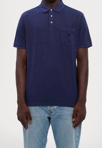 Námořnický polos tričko vyrobené z bavlny, se límečkem, zapínáním na tři knoflíky a kapsou na levé hrudi s logem. Pohodlný střih.