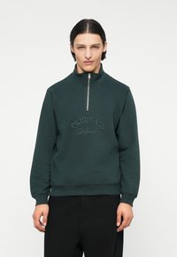 Donkergroene zip-up sweatshirt met hoge kraag, geperst "ORIGINALS" logo op de borst, ribgebreide manchetten en zoom. Glad textielstof.