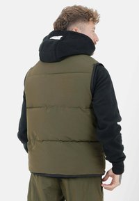 Chaleco acolchado verde oliva con capucha de forro polar negro y mangas largas, con costuras horizontales y un corte relajado.