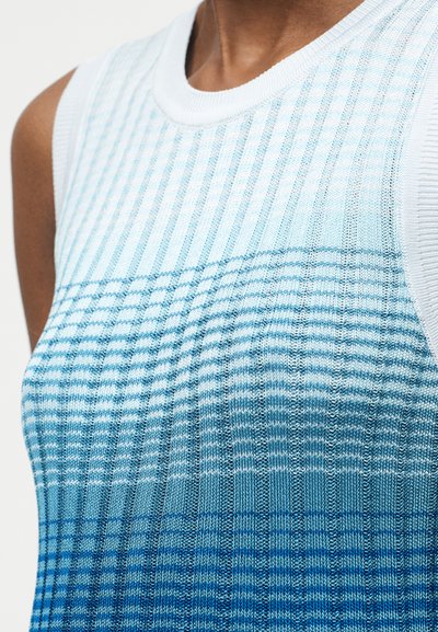 Αμάνικη πλεκτή μπλούζα με ριμπ υφή, με κάθετες και οριζόντιες διαβαθμισμένες ρίγες σε αποχρώσεις λευκού και μπλε.