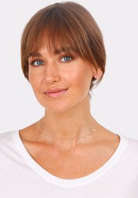 Gold choker necklace featuring a delicate chain and a small crescent charm. Worn on a light background with a white V-neck shirt.