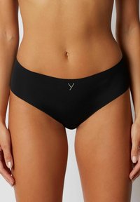 Slip negru din bikini, din material neted, cu tăietură joasă și detaliu logo discret în partea din față. Prezintă un design minimalistic și margini fără cusături.