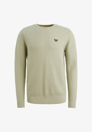 Světle zelený svetr s texturovaným pletením, s kulatým výstřihem a dlouhými rukávy. Na levém prsu je umístěný vyšívaný emblém.