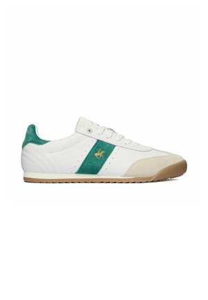 Hvid lav sneaker med grøn ruskindstribe og hæl, beige tåhætte, snørelukke og brun gummisål, sidevisning.