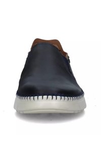 Scarpe slip-on in pelle navy con superficie liscia, dettagli in marrone a contrasto e suola bianca cucita. Forma complessivamente arrotondata.