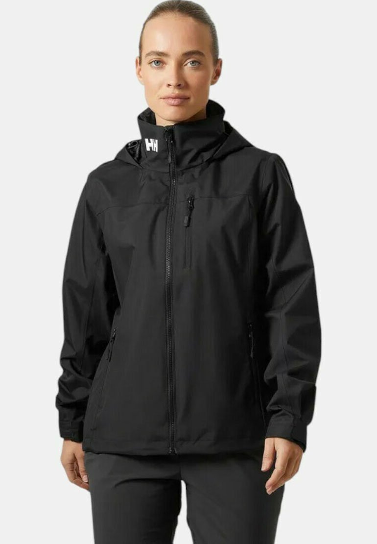 Chaqueta impermeable negra con capucha, cremallera frontal y bolsillos con cremallera, diseñada con un acabado mate suave y puños ajustables.