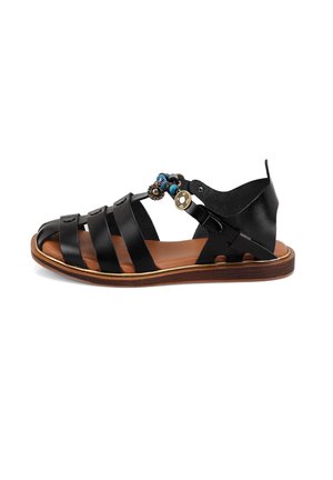 Schwarze Leder-Sandale mit mehreren Riemen, brauner Innensohle und dekorativen Perlenverzierungen an der Seite. Flache Sohle, offenes Rückendesign.