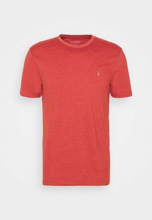 T-shirt en coton rouge avec un col rond, des manches courtes et un petit logo blanc sur la poitrine gauche. Texture lisse, coupe standard.
