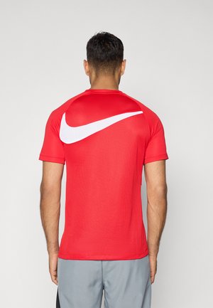 Rode Nike sport t-shirt met korte mouwen, gestructureerde stof en een grote witte swoosh-afbeelding op de achterkant.