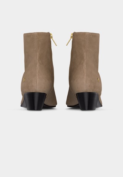 Ζευγάρι ταμπά ανδρικών μποτάκια από σουέντ με μαύρα chunky τακούνια και χρυσά φερμουάρ, από την πίσω πλευρά σε λευκό φόντο.