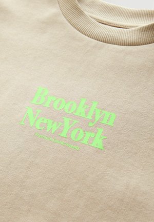 Beżowa bluza z okrągłym dekoltem i prążkowanym wykończeniem, z jasn.Green tekstem "Brooklyn Nowy Jork" oraz napisem "Premium Goods Supply" poniżej.