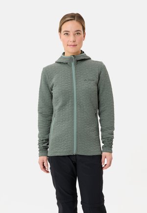 Veste en polaire verte matelassée avec capuche, fermeture éclair avant et deux poches latérales. Elle présente un motif texturé et une couleur de fermeture éclair contrastante.
