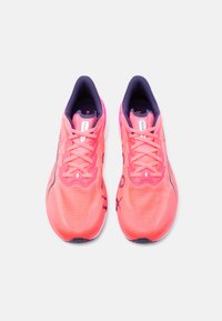 Φωτεινά κοραλλί ροζ αθλητικά παπούτσια με εσωτερική επένδυση και κορδόνια σε σκούρο ναυτικό μπλε, τοποθετημένα δίπλα δίπλα και στραμμένα προς τα εμπρός σε λευκό φόντο.