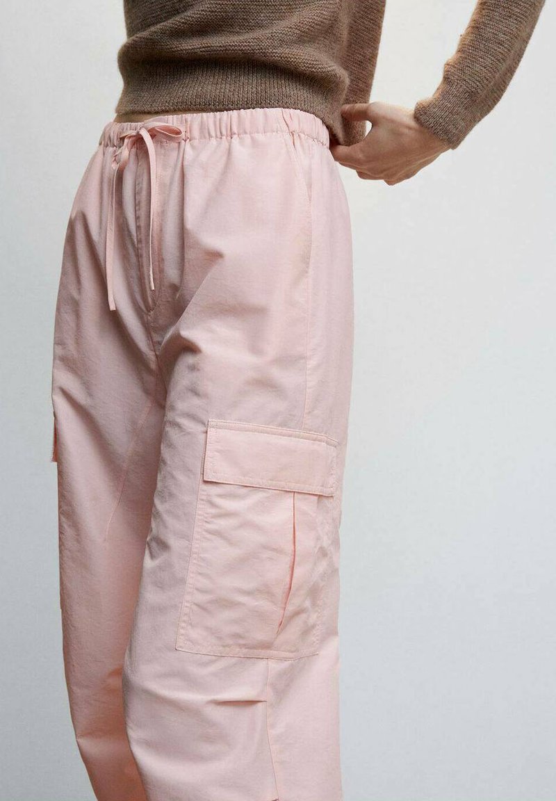 Pantalones cargo rosas hechos de una tela ligera, con cintura ajustable, bolsillos laterales y un ajuste relajado. La textura parece suave.