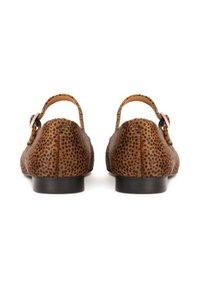 Chaussures marron à pois avec une texture en cuir lisse, dotées d'une lanière arrière et d'un petit talon rond. Accent de boucle décorative.