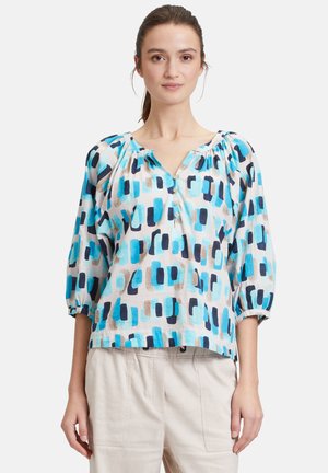 Leichte, gemusterte Bluse in Blau, Aqua und Braun. Mit V-Ausschnitt, Puffärmeln und Knopfdetails an der Vorderseite.
