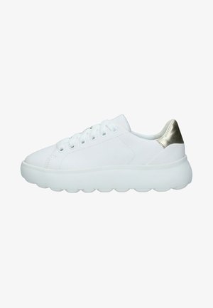 Zapatilla blanca de corte bajo con suela gruesa y lengüeta metálica dorada en el talón, con cierre de cordones y parte superior de cuero liso.
