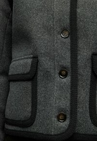 Gray wool-blend jacket with black trim, featuring four buttons, two front pockets, and smooth texture. Tailored design with clean lines.
