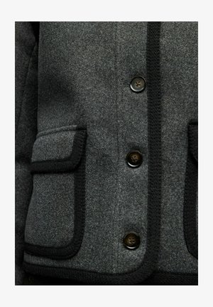 Giacca grigia in misto lana con bordi neri, caratterizzata da quattro bottoni, due tasche frontali e una trama liscia. Design su misura con linee pulite.