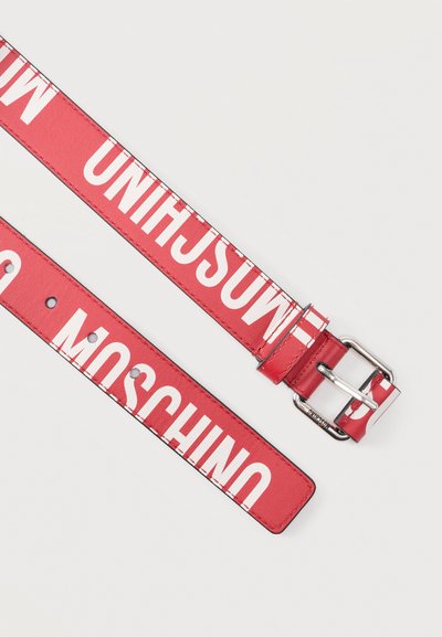 Κόκκινη δερμάτινη ζώνη με ασημένια πόρπη, που φέρει μεγάλο λευκό κείμενο «MOSCHINO» τυπωμένο κατά μήκος της.