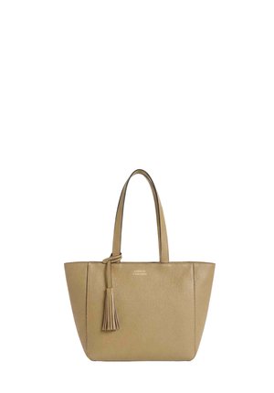 Sac fourre-tout en cuir beige avec deux bandoulières et un gland décoratif suspendu à l'une des bandoulières.