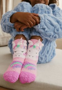 Miękkie, puszyste skarpetki z wzorem jednorożca w różowo-fioletowych odcieniach z motywem tęczy. Skarpetki mają fakturowane wykończenie i kolorowe akcenty.