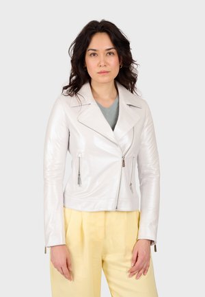 Veste de biker en cuir blanc avec poches zippées, col cranté et texture lisse. Associée à un pantalon jaune pâle et un haut vert en dessous.