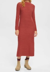 Robe en maille bordeaux à manches longues, col rond et silhouette cintrée, présentant un motif texturé et une longueur mi-mollet.