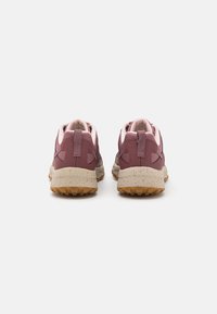 Baskets de sport violettes et roses avec un dessus texturé, un col rembourré, une semelle en caoutchouc et une semelle intermédiaire mouchetée. Deux bandes de traction pour un enfilage facile.