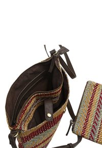 Tekstil håndtaske med flerfarvet zigzag mønster. Brune læderdetaljer, lynlås lukning, og en lille matchende pung inkluderet.