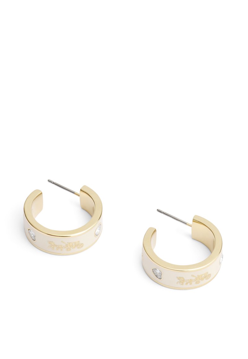 Boucles d'oreilles créoles en ton or avec une finition lisse, des détails gravés et de petites accents en pierres précieuses claires de chaque côté.