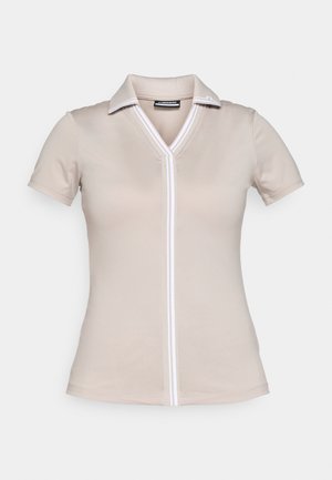 Beige polo shirt with a white trim, short sleeves, and a V-neck. Made of smooth, stretchy fabric. Includes subtle logo detail on the collar.